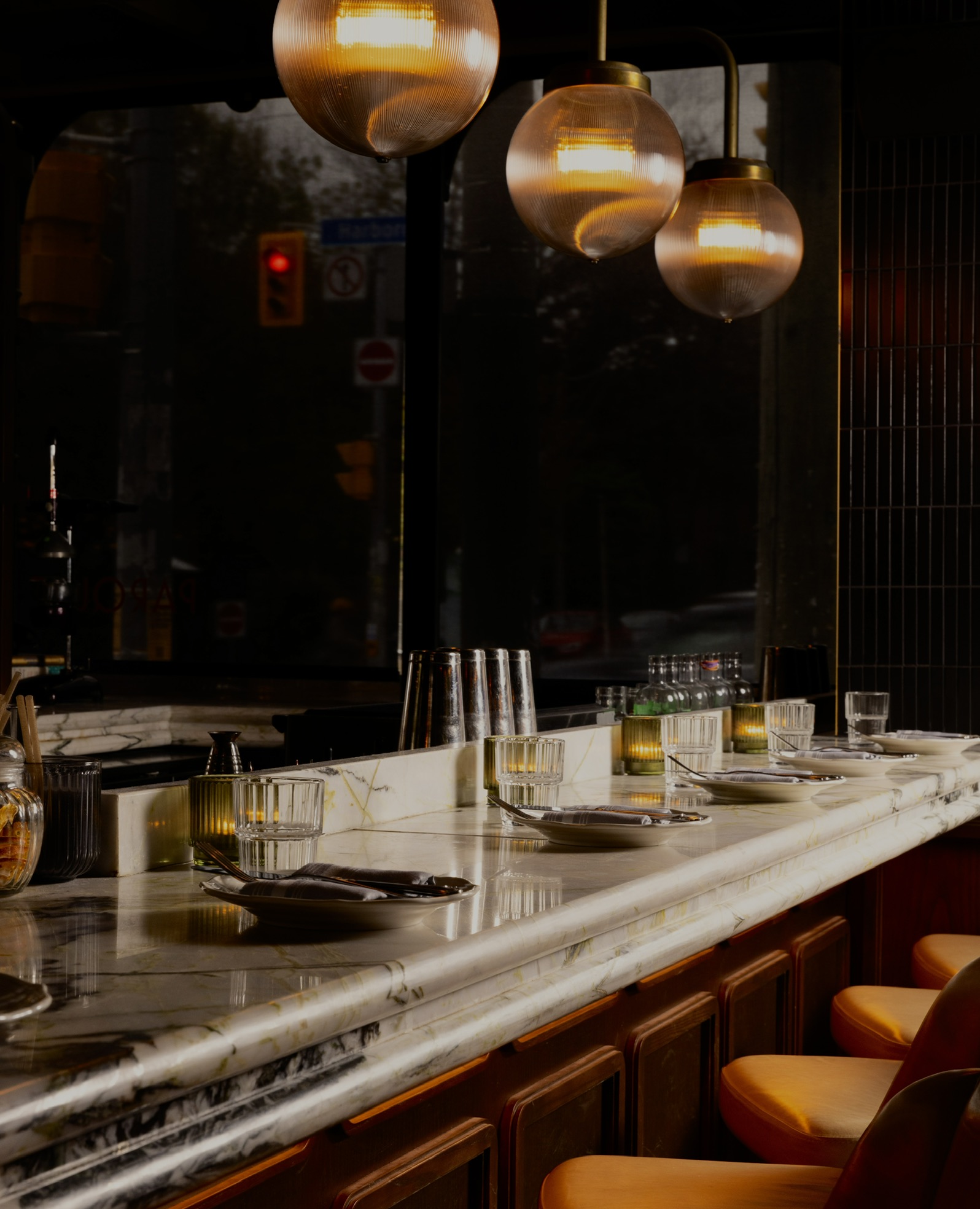 The marble bar at Parquet, lit by globe pendants